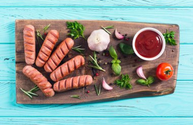 Otlar, baharatlar ve ketçap ile kızarmış sosis