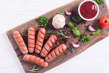 Otlar, baharatlar ve ketçap ile kızarmış sosis
