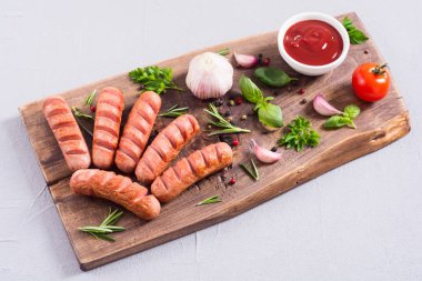 Otlar, baharatlar ve ketçap ile kızarmış sosis