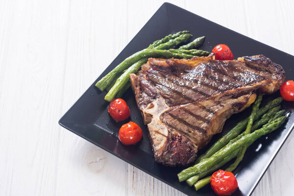 Grilled T-bone steak with asparagus and cherry tomatoes 