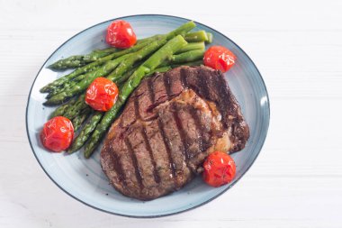 Kiraz domates ve kuşkonmaz ile ızgara sığır biftek ribeye