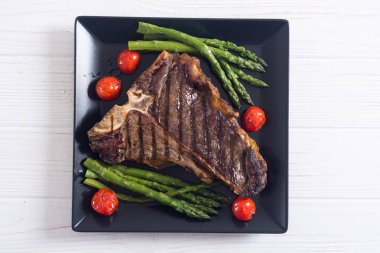 Kuşkonmaz ve kiraz domates ile ızgara T-kemik biftek 