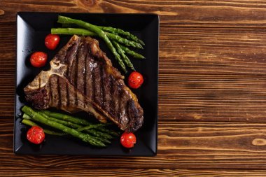 Kuşkonmaz ve kiraz domates ile ızgara T-kemik biftek 