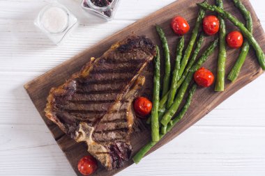 Kuşkonmaz ve kiraz domates ile ızgara T-kemik biftek 