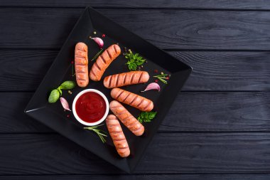 Otlar, baharatlar ve ketçap ile kızarmış sosis