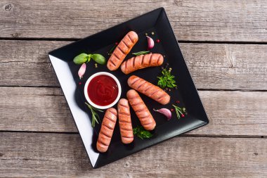 Otlar, baharatlar ve ketçap ile kızarmış sosis