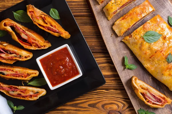 Pizzabrötchen stromboli mit Käsesalami Oliven und Tomaten — Stockfoto
