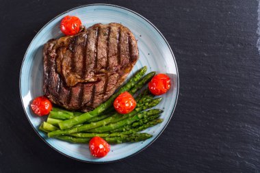 Kiraz domates ve kuşkonmaz ile ızgara sığır biftek ribeye