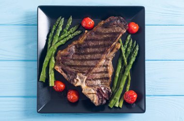 Kuşkonmaz ve kiraz domates ile ızgara T-kemik biftek 