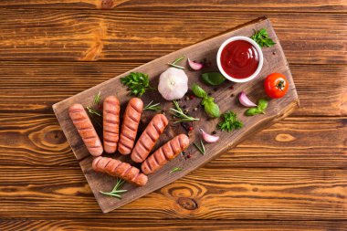 Otlar, baharatlar ve ketçap ile kızarmış sosis