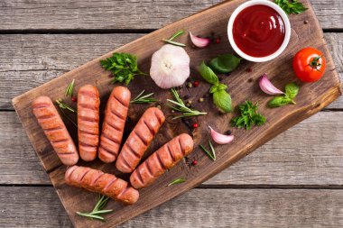 Otlar, baharatlar ve ketçap ile kızarmış sosis