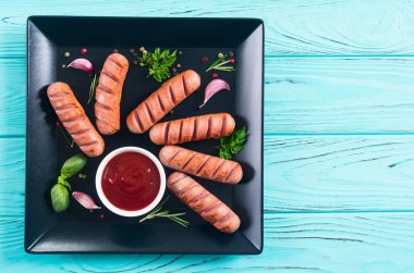 Otlar, baharatlar ve ketçap ile kızarmış sosis