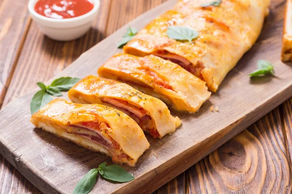 Pizzabrötchen stromboli mit Käsesalami Oliven und Tomaten — Stockfoto