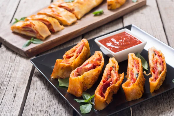 Pizza roll Stromboli se sýrem salám olivy a rajčata — Stock fotografie