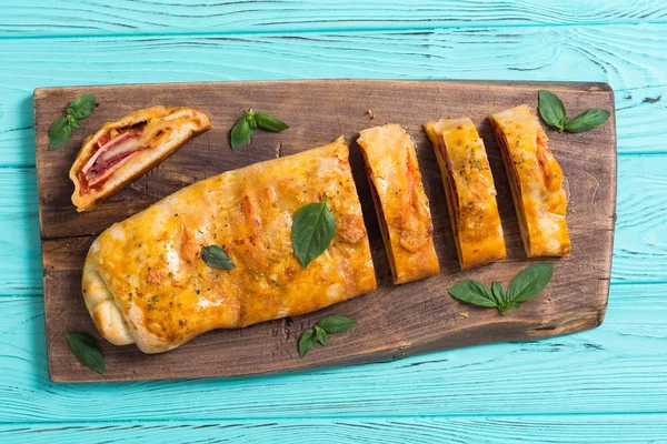 Pizza roll Stromboli se sýrem salám olivy a rajčata — Stock fotografie