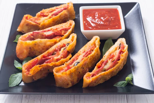 Pizzabrötchen stromboli mit Käsesalami Oliven und Tomaten — Stockfoto