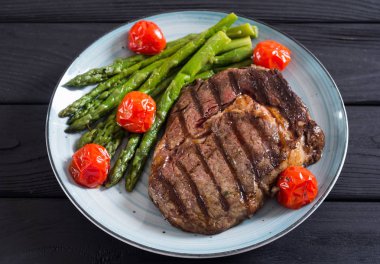 Kiraz domates ve kuşkonmaz ile ızgara sığır biftek ribeye