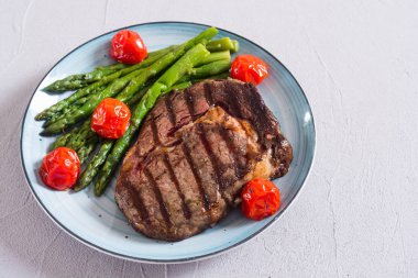 Kiraz domates ve kuşkonmaz ile ızgara sığır biftek ribeye