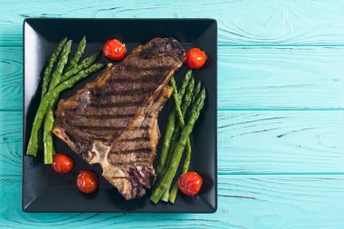 Kuşkonmaz ve kiraz domates ile ızgara T-kemik biftek 