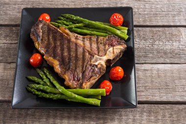 Kuşkonmaz ve kiraz domates ile ızgara T-kemik biftek 