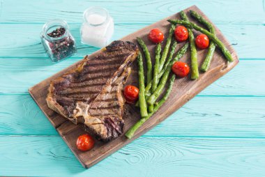 Kuşkonmaz ve kiraz domates ile ızgara T-kemik biftek 