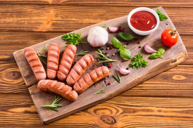 Otlar, baharatlar ve ketçap ile kızarmış sosis