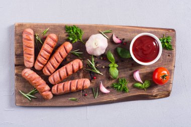 Otlar, baharatlar ve ketçap ile kızarmış sosis