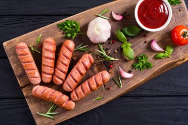 Otlar, baharatlar ve ketçap ile kızarmış sosis