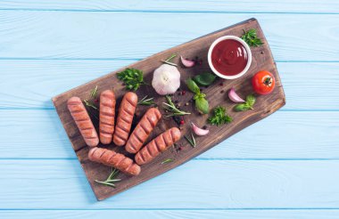 Otlar, baharatlar ve ketçap ile kızarmış sosis