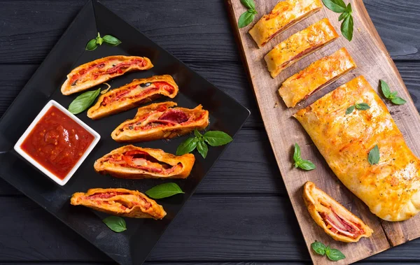 Pizza rulle Stromboli med ostsalami oliver och tomater — Stockfoto