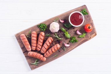 Otlar, baharatlar ve ketçap ile kızarmış sosis