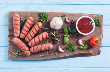 Otlar, baharatlar ve ketçap ile kızarmış sosis