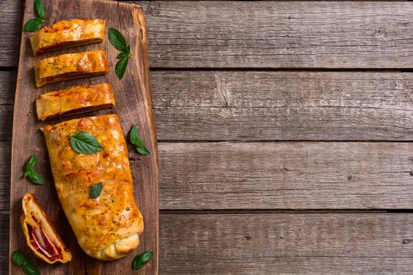 Pizzabrötchen stromboli mit Käsesalami Oliven und Tomaten — Stockfoto