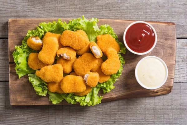 Chicken nuggets in plate on rustic background — Stock Photo, Image