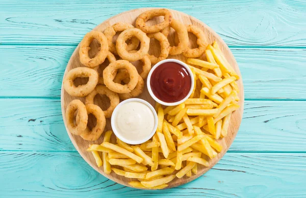 Pommes frites och lökringar med såser — Stockfoto