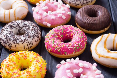 Çikolata kaplı, pembe jöleli ve serpiştirilmiş çeşitli çörekler. Üst görünüm