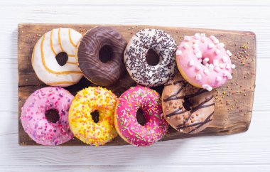 Çikolata kaplı, pembe jöleli ve serpiştirilmiş çeşitli çörekler. Üst görünüm