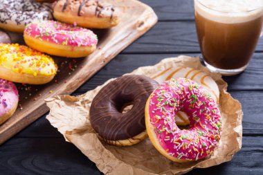 Çikolata kaplı, pembe jöleli ve serpiştirilmiş çeşitli çörekler. Üst görünüm