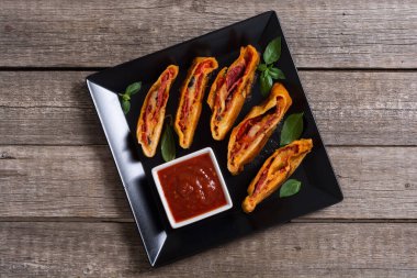 İtalyan yemeği peynirli, salamlı, zeytinli ve domatesli pizza. 