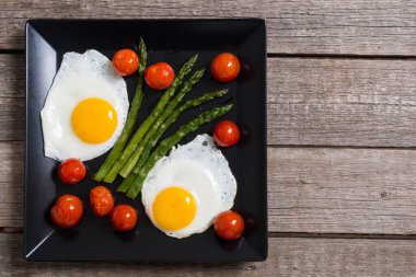 Yumurta, kuşkonmaz ve domatesli sağlıklı bir kahvaltı. Sebze arka planı