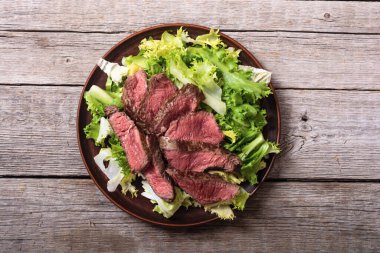 Kızarmış biftekli salata. Ahşap arka planda