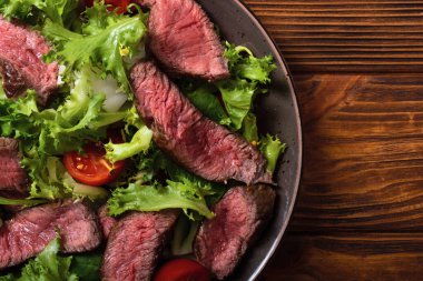 Kızarmış biftekli salata. Ahşap arka planda