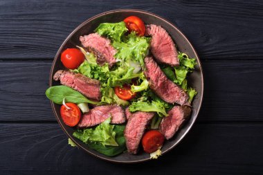 Kızarmış biftekli salata. Ahşap arka planda