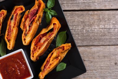 İtalyan yemeği peynirli, salamlı, zeytinli ve domatesli pizza. 