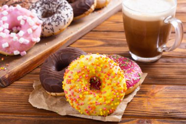 Çikolata kaplı, pembe jöleli ve serpiştirilmiş çeşitli çörekler. Üst görünüm