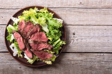 Kızarmış biftekli salata. Ahşap arka planda