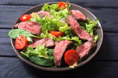 Kızarmış biftekli salata. Ahşap arka planda