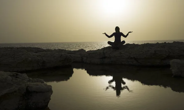 瑜伽中的女人在海边摆姿势 女人的剪影反映在小湖中 Evenig 的光就像金子一样 — 图库照片
