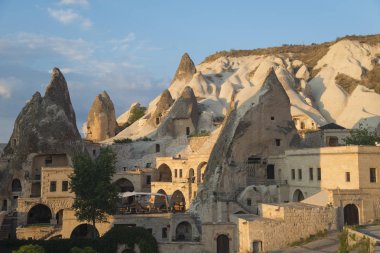 Kapadokya'nın kayalıklarında konutlar. Arka planda mavi gökyüzü.