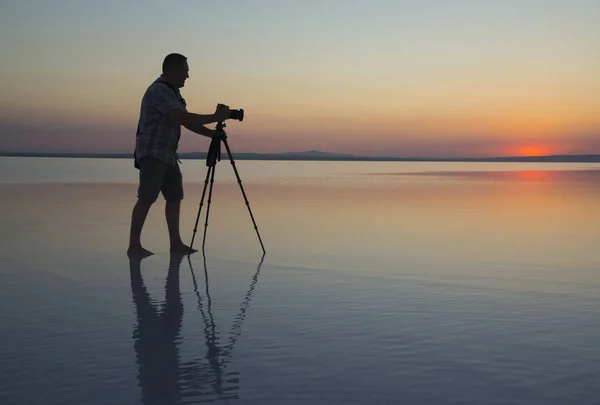 Solnedgång, sjö och photgrapher — Stockfoto